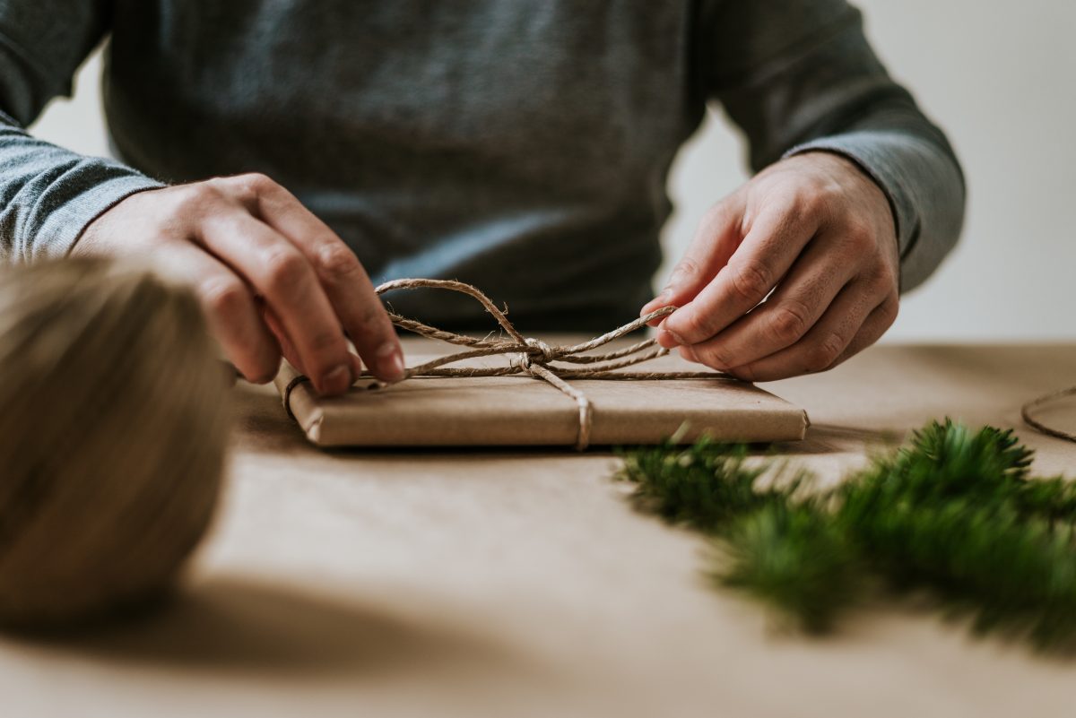 Person wrapping a Christmas present in sustainable paper