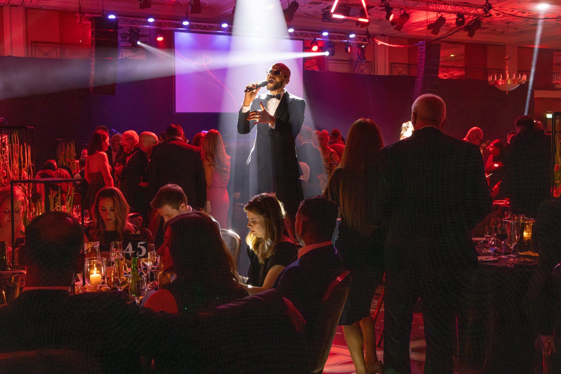 Man singing into microphone at event.