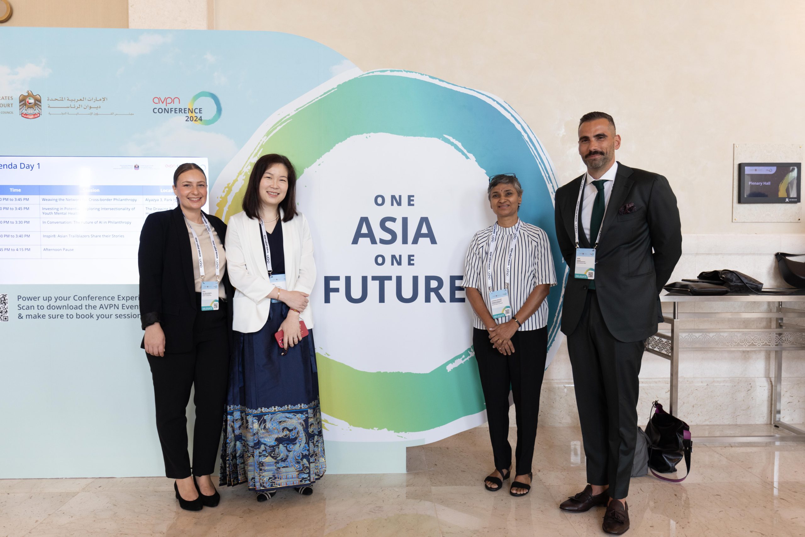 AVPN Global Conference delegates standing in front of branding and digital schedule