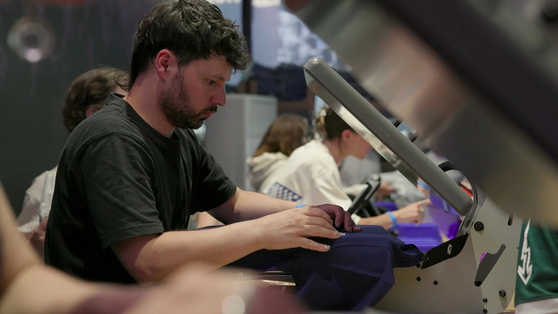 A team member customises Quadrant apparel inside the Mod Shop at Outernet London