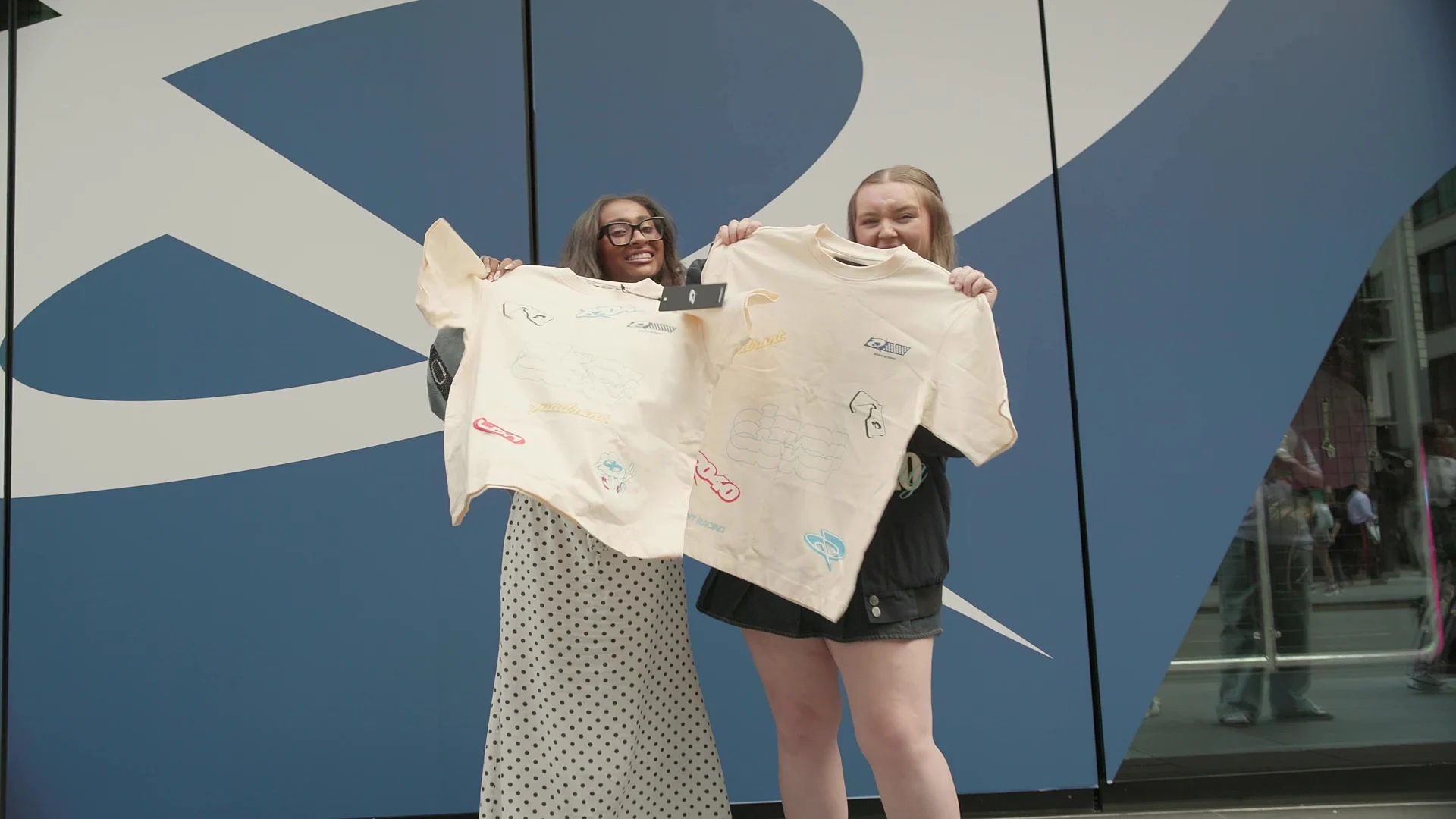 Two fans display customised Quadrant T-shirts outside the pop-up at Outernet London