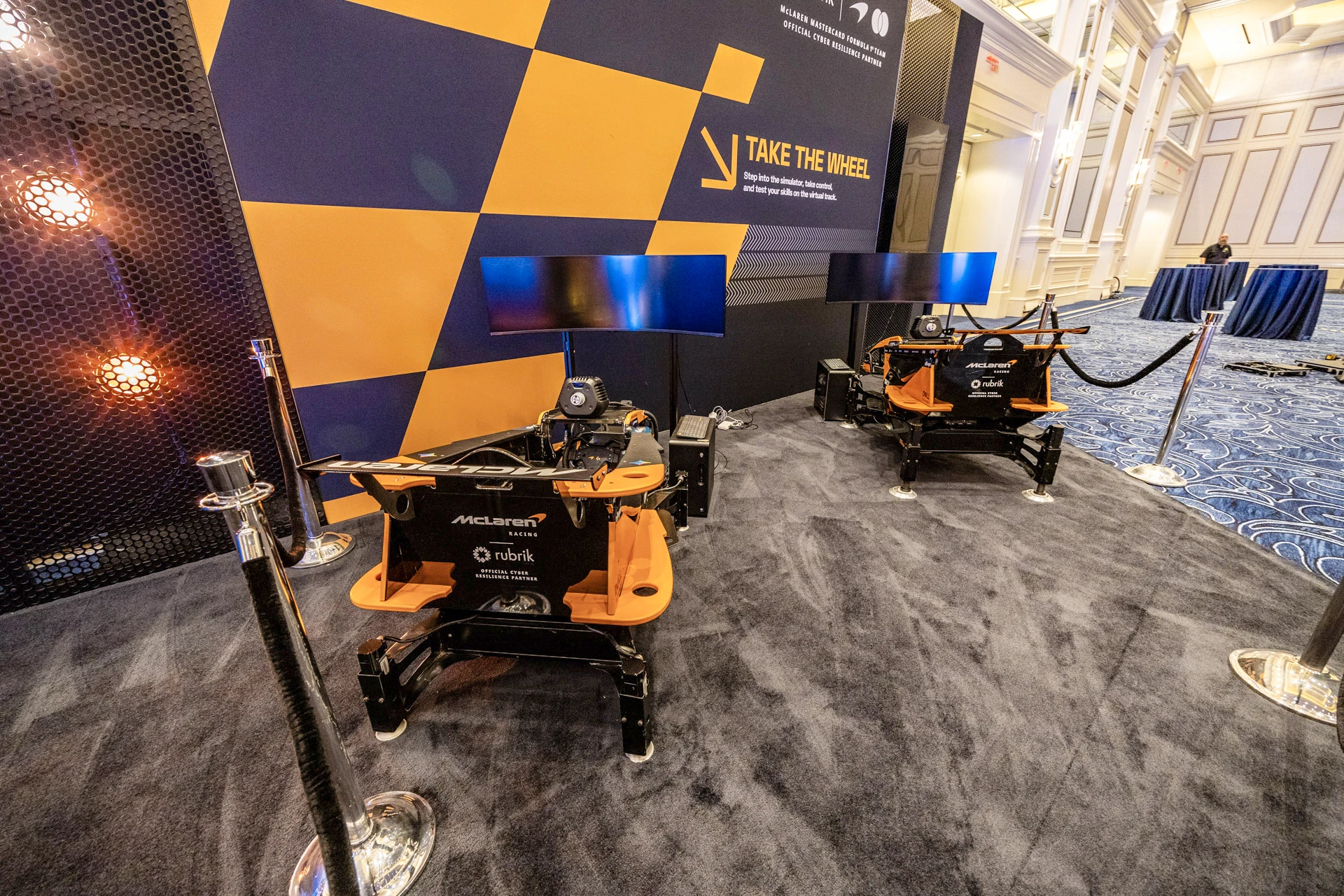 McLaren Formula 1 car displayed alongside Rubrik Forward branding and digital screens