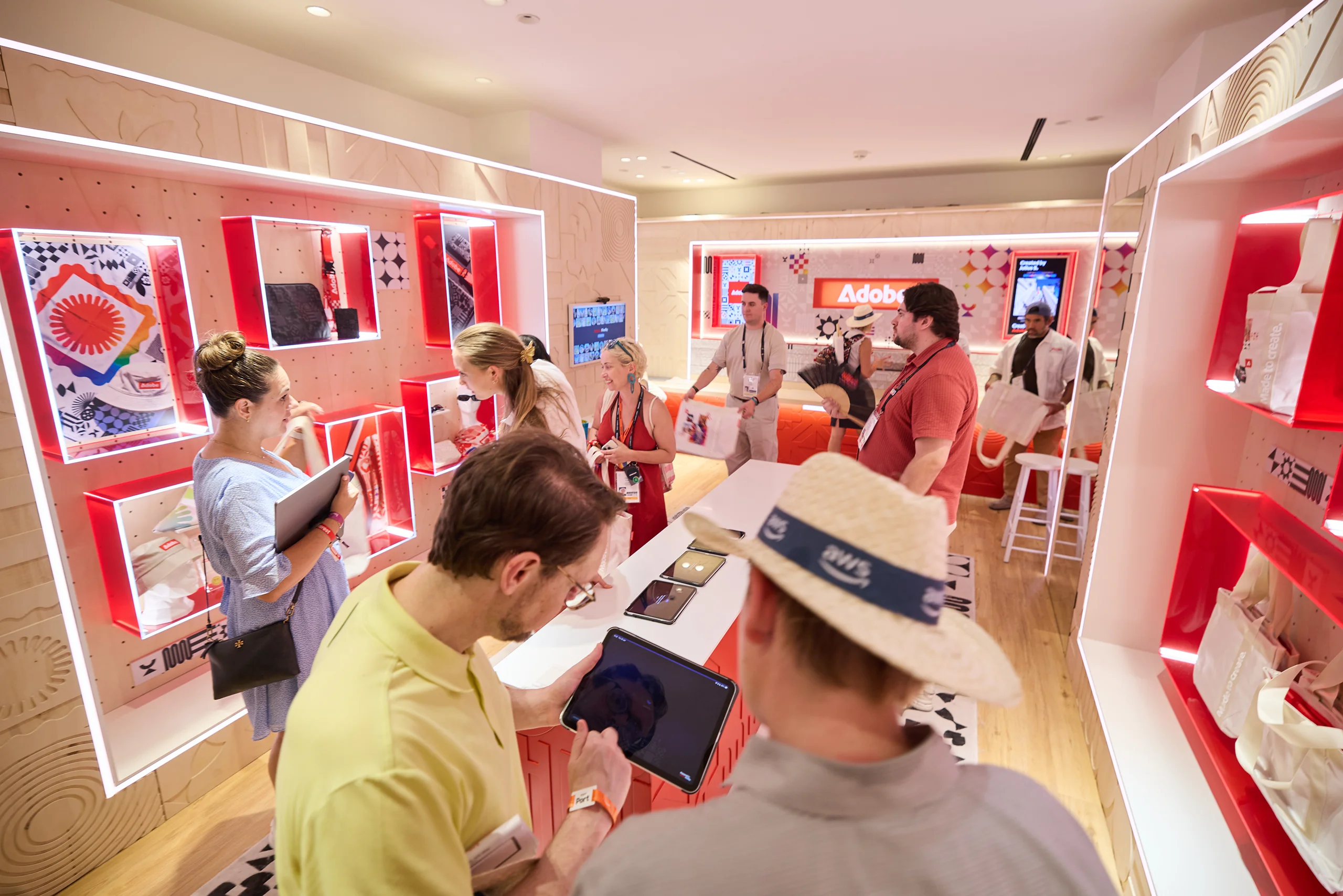Visitors exploring Adobe product demonstrations on tablets inside a branded Cannes Lions experience space