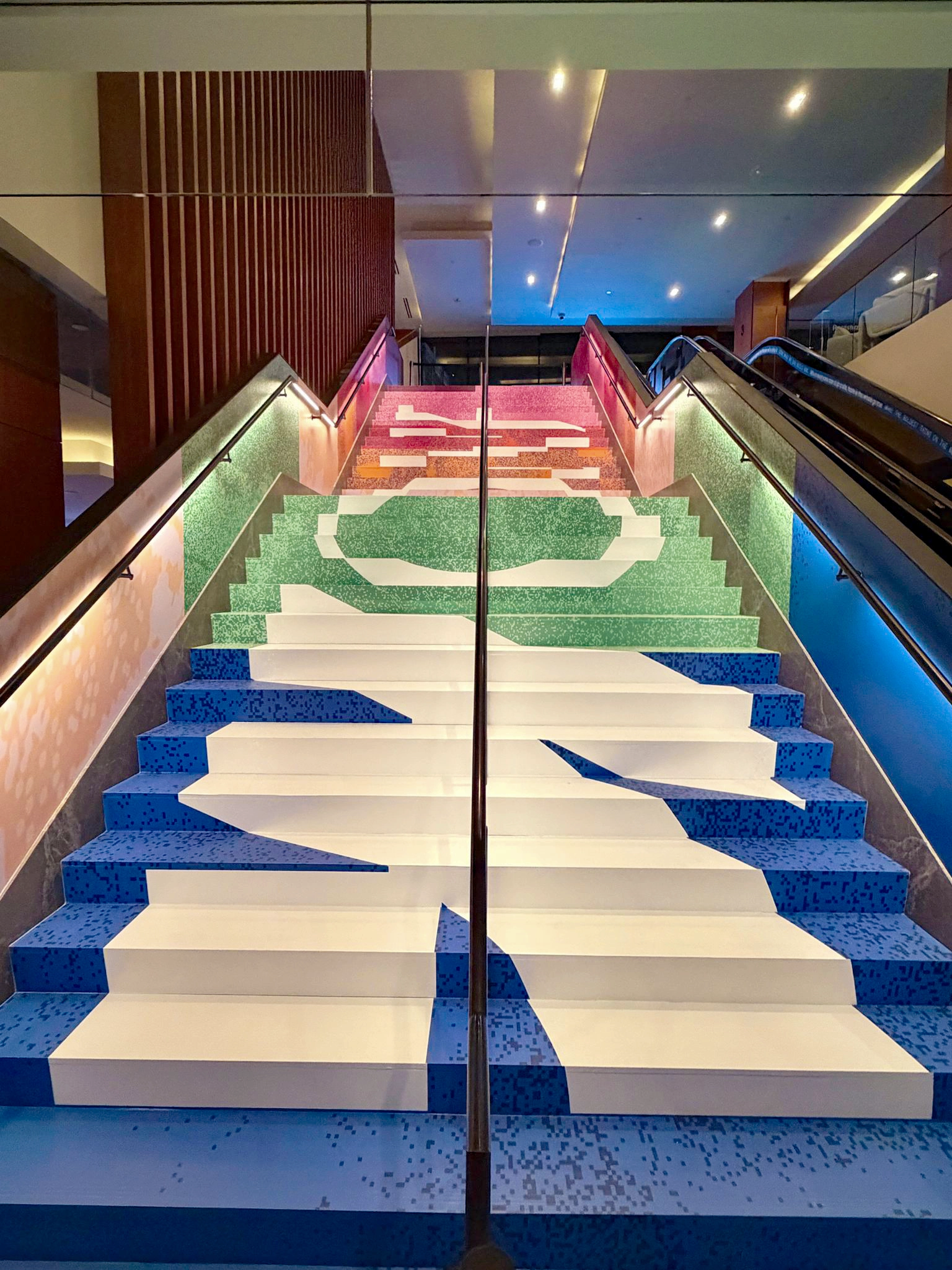 Webflow Conf staircase featuring colourful geometric graphics in blue, green and pink